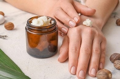 Nahaufnahme von Hände tragen pflegende Sheabutter auf, natürliche Feuchtigkeitspflege für trockene Haut