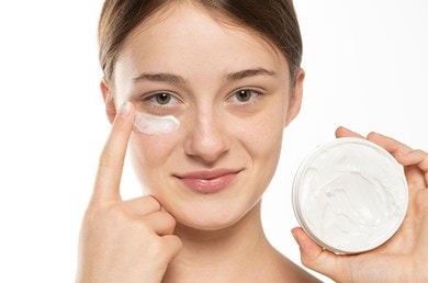 Junge Frau trägt Creme unter den Augen auf, erfrischender Feuchtigkeitskick für müde Haut