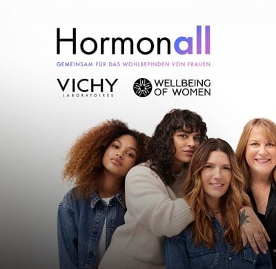 Eine Gruppe von Frauen in legerer Kleidung vor einem Hintergrund mit den Logos von Hormonall, Vichy Laboratories und Wellbeing of Women.
