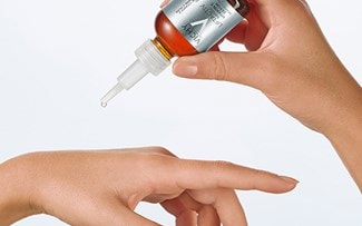 Person tröpfelt ein wenig Vichy LIFTACTIV Serum auf ihren Handrücken
